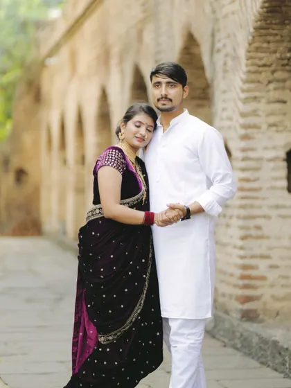 A classic pose showing their deep connection. The bride's traditional Navari saree and the groom's white kurta make for a beautiful and authentic pre-wedding photo.