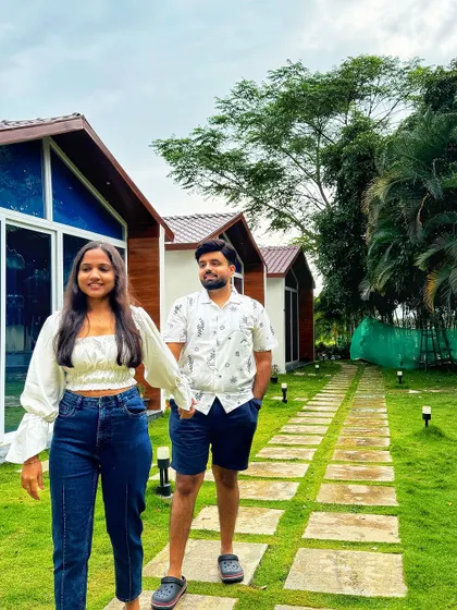 A couple enjoying a walk past the modern cabins at our Nandi Hills resort. The well-maintained pathways and lush lawns make for a pleasant stroll.