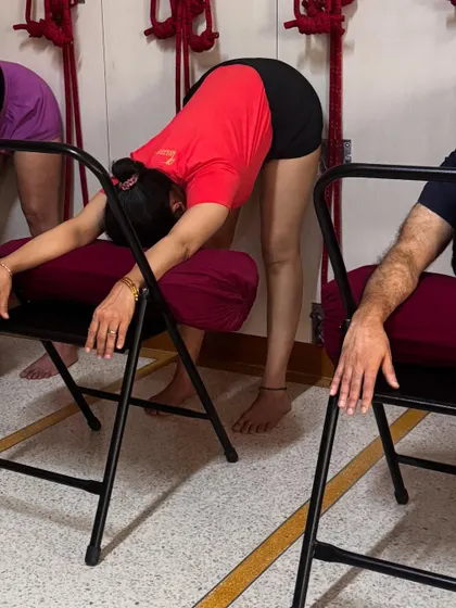To de-stress, a supported forward bend over a chair can be profoundly calming. Resting the torso and head allows the back muscles to release and the mind to quiet. This is part of a sequence designed to bring the body and mind into a state of balance and peace.