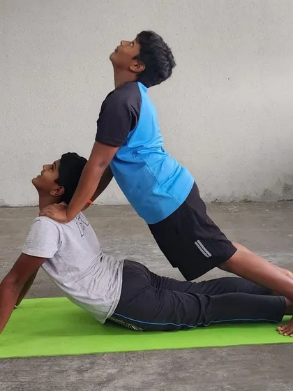 This assisted upward-facing dog helps deepen the backbend and open the chest, with the partner providing gentle, supportive pressure.