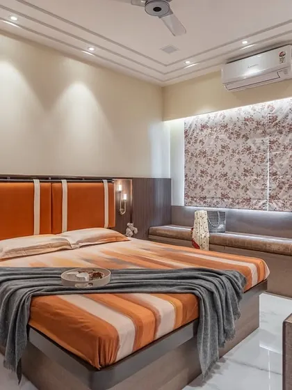 This angle highlights the ambient lighting in the warm-toned bedroom. Sconces on the headboard panel and backlighting behind the floral roman blinds create a soft, inviting glow perfect for winding down.