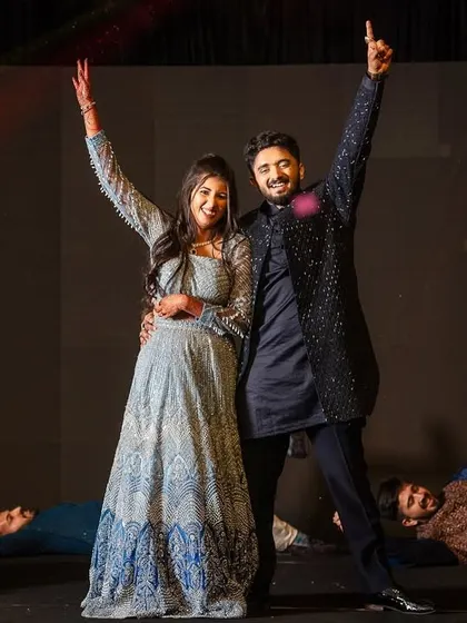 The finale pose of an energetic friends' performance, with the couple taking center stage.