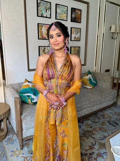 The full look for the Haldi ceremony, with the colorful floral braid complementing the bride's yellow outfit. She looks radiant and ready to celebrate.