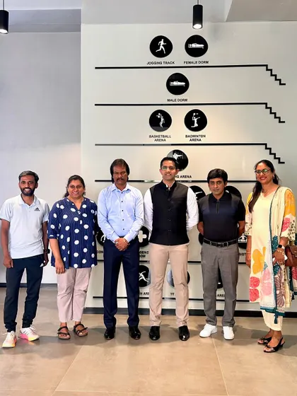 A group photo with our distinguished guests, including hockey legends and Olympians, in front of our facility's directional signage.