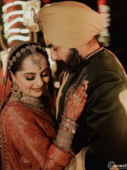 A beautiful, warm-toned portrait of a Sikh couple sharing an intimate moment during their wedding celebrations.
