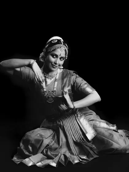 A black and white studio shot of Ambili Krishnan, highlighting the classic lines and form of her posture.