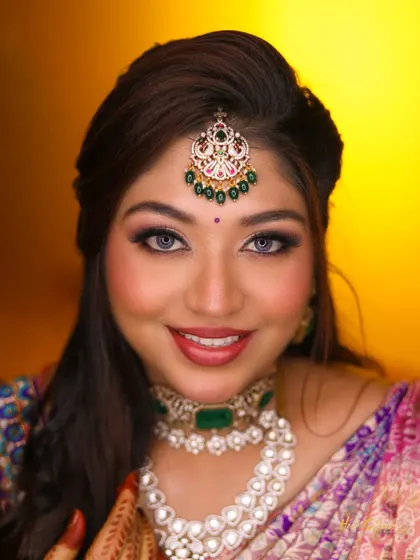 A close-up portrait of the bride, her bright smile and beautiful makeup making for a joyful and vibrant shot.