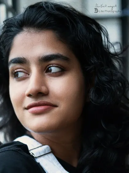 A close-up, natural portrait of the same model. The focus is on her genuine expression and the soft, natural light.