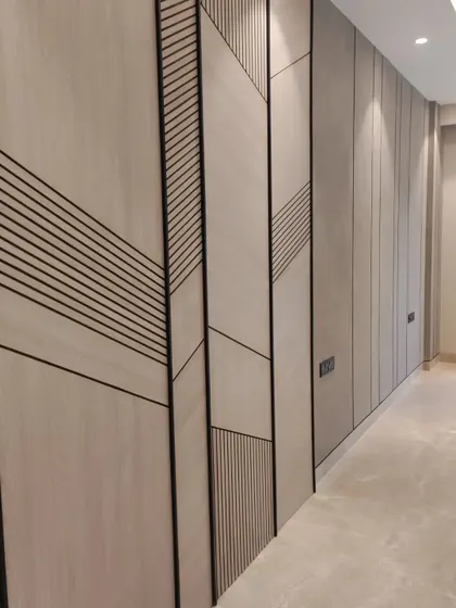 The project nearing completion. This image shows the installation of a custom wall panel with geometric grooves, a design element that adds texture and character before the final furnishings are brought in.