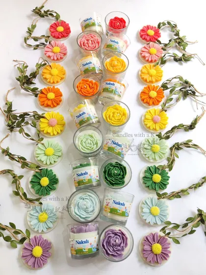 A vibrant assortment of peony votive candles and daisy wax sachets, created as personalized birthday return gifts.