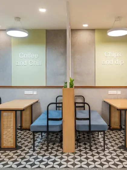 The completed cafe-style breakout area, perfectly matching our initial render. This space features booth seating with custom upholstery, patterned floor tiles, and decorative wooden screens.