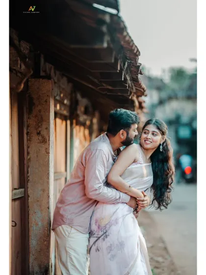 An intimate and romantic embrace against the backdrop of an old village house, capturing a tender pre-wedding moment.