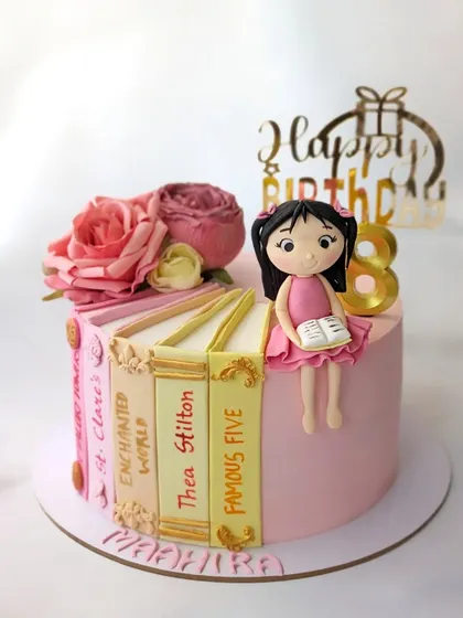 For a little girl who loves to read. This cake is designed to look like a stack of her favorite books, including titles by Enid Blyton and Thea Stilton.