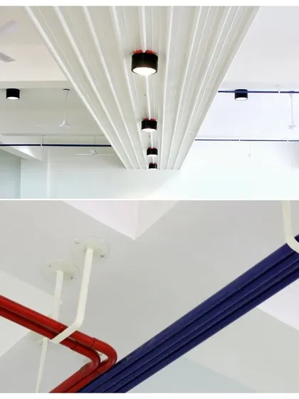 This was a fun project for Ananya Technologies. We took inspiration from a circuit board, using color-coded red and blue pipes as electrical conduits that run across the ceiling, saving costs and creating a unique industrial aesthetic.