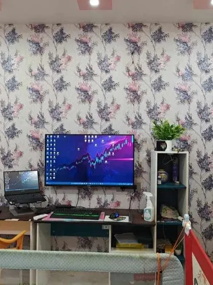 A delicate floral vine wallpaper used in a home office setup. The pattern adds a touch of softness and nature to the workspace without being distracting.