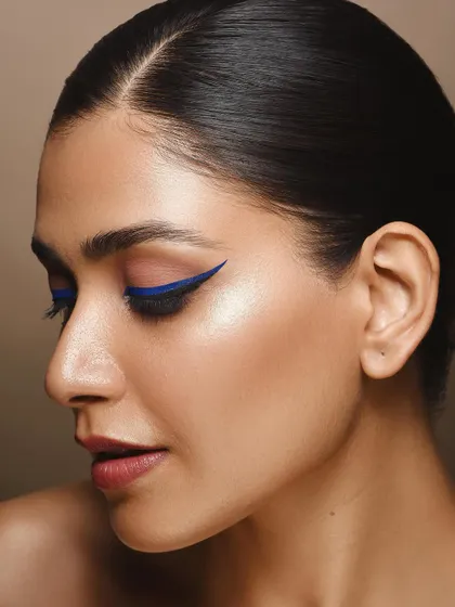 This profile shot offers a different perspective on the makeup, highlighting the clean line of the eyeliner and the contour of the face. It shows versatility in capturing a single look from multiple angles.