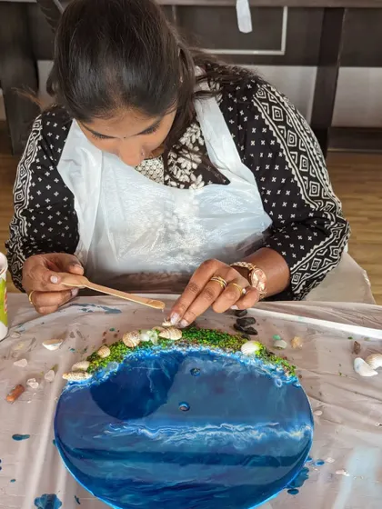 Adding shells and other embellishments to a resin beach clock. These small details bring the entire piece to life.