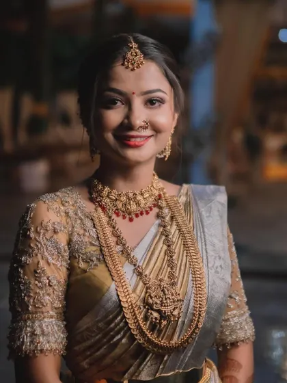 This bride's Muhurtham look is the epitome of South Indian grace. Her makeup is kept classic and radiant, paired with heavy gold temple jewellery and a traditional nose ring.