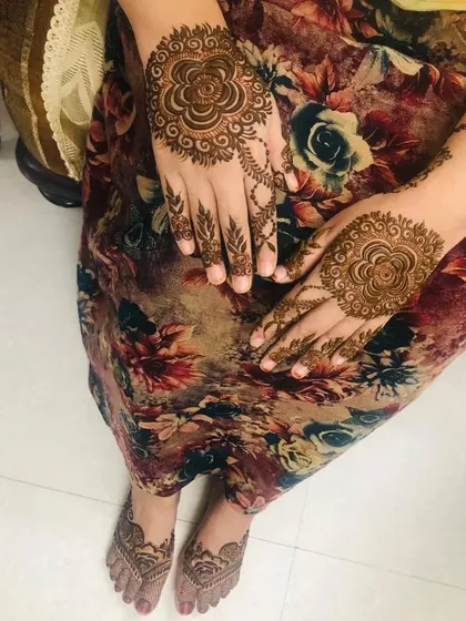 A simple and elegant design for the back of the hands and feet, featuring a central mandala motif. Perfect for a guest or a smaller occasion.