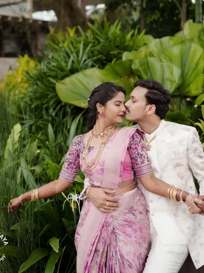 A beautiful portrait of the couple from their engagement shoot, surrounded by lush greenery.