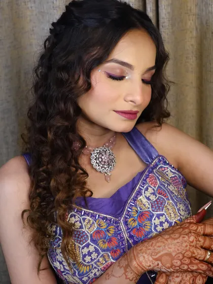 The eye makeup for this look features a blend of purple and neutral tones with a touch of sparkle, a versatile technique for aspiring makeup artists to learn.