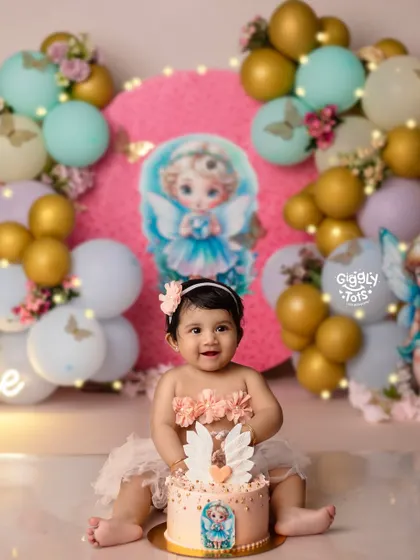 One-derful and covered in cake! This little angel is having a heavenly time with her first birthday cake.