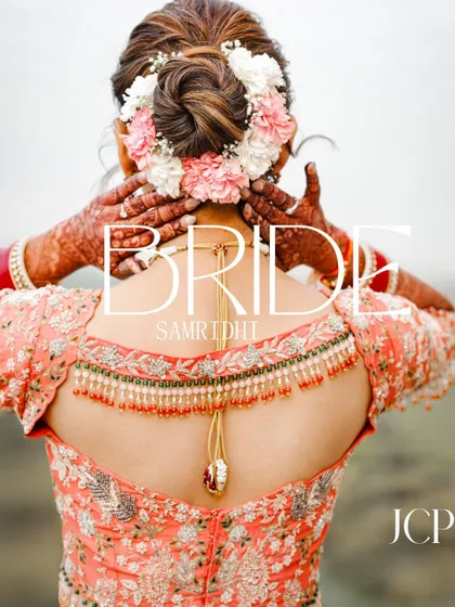 A creative bridal portrait focusing on the beautiful floral hair bun and intricate blouse back.