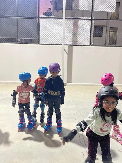 A young girl with glasses smiles brightly, showing the fun and confidence she's found in our skating class.