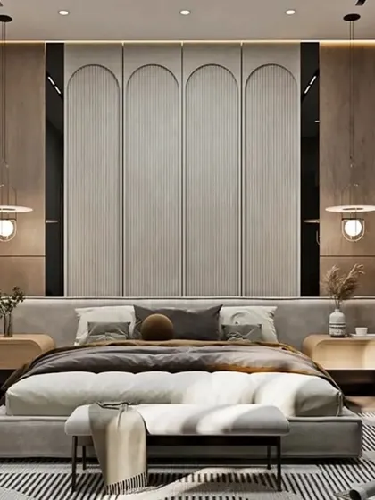 An elegant master bedroom featuring a tall, arched panel headboard and sophisticated pendant lighting. The neutral color scheme and soft textures create a serene and luxurious retreat.