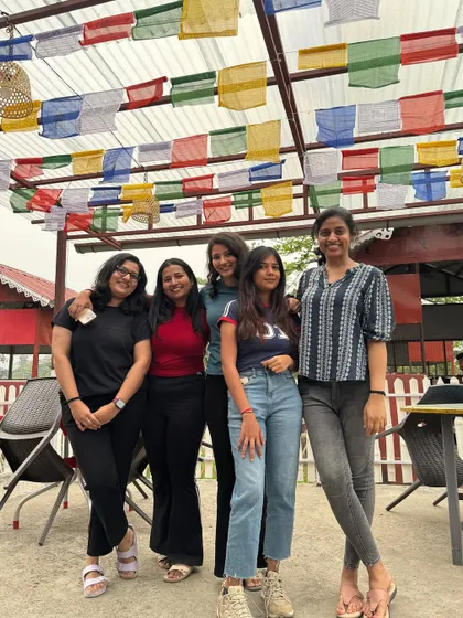 Relaxing after a day's trek. Here, a few members of our group unwind at a local cafe, surrounded by the vibrant prayer flags that are a common sight in the region.