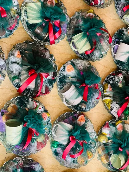 A detailed shot of the wrapped Christmas hampers, highlighting the festive colors and contents.