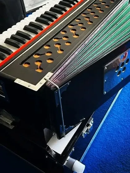 This dark brown folding harmonium is ready for delivery. It features a coupler and a bass-male reed setup, making it a versatile and portable choice for traveling musicians.