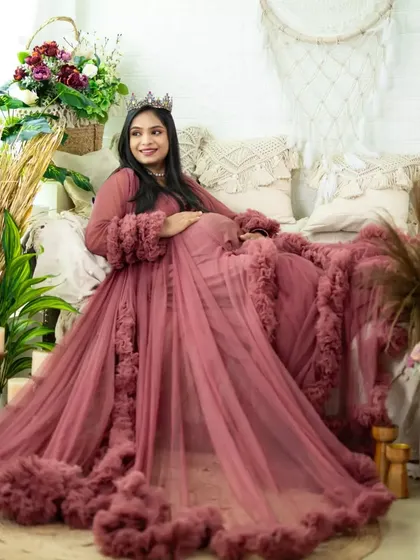 A beautiful portrait in our boho studio. The mom-to-be is seated in a dusty rose gown, surrounded by pampas grass and flowers, looking serene and radiant.