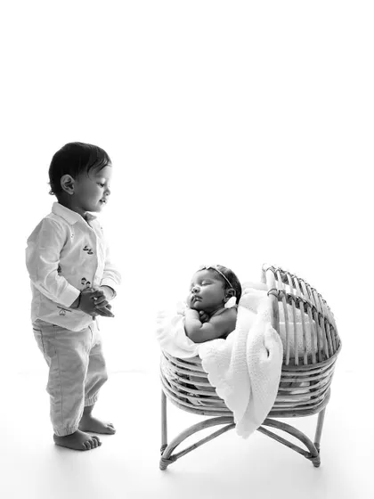 The same precious moment in black and white. The monochrome edit gives this sibling portrait a timeless and classic feel, emphasizing the emotion of the scene.