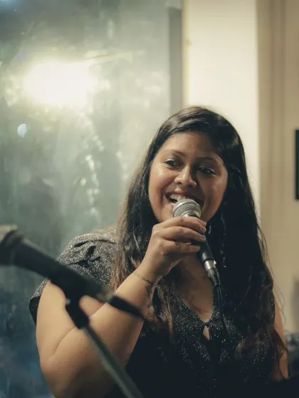 A vocalist from the 90's Jukebox band, smiling and connecting with the audience. Our shows are as much about community as they are about music.