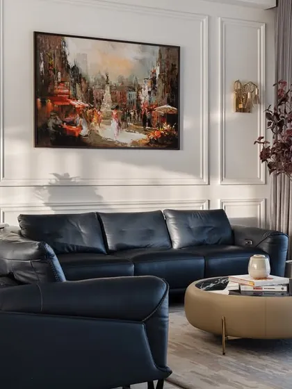 This view highlights the balance of color and texture in the living room. The dark leather sofa provides a strong anchor, while the tan lounge chair adds a pop of warmth and personality to the space.
