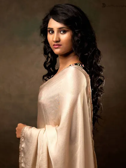 A profile shot of Priyadarshini SK against the studio backdrop, highlighting her features and the elegant drape of the saree.