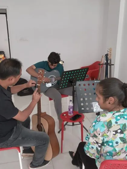 A guitar class in session. We have guitars available for students to use at the center.