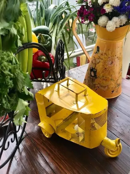 A quirky, yellow auto-rickshaw miniature used as a decor piece. We love incorporating fun and unique objects that add character and a talking point to our event styling.