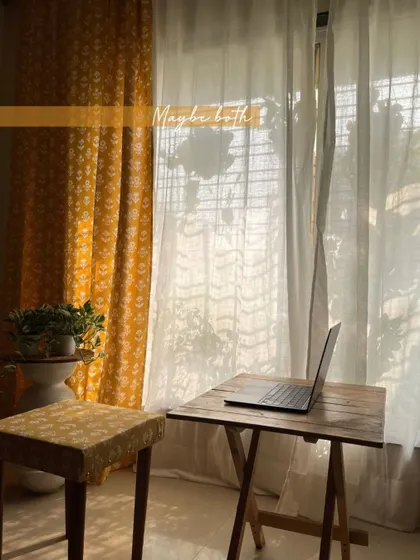 One fabric, two stories. Here, our yellow block-print fabric is used for both curtains and a custom-upholstered ottoman, creating a coordinated and stylish look in this sunny work-from-home corner.