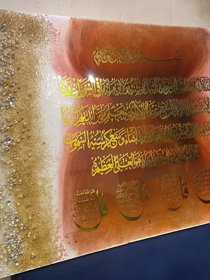 The warm-toned Ayat al-Kursi and Four Quls piece, shown from an angle to reveal its depth and texture.