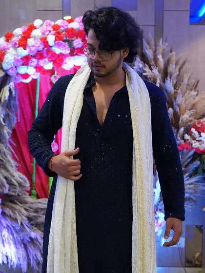 Dressed in a traditional navy blue kurta for a family engagement ceremony. I always make sure to dress for the occasion, adding to the elegance of your event.