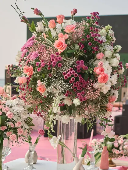 A lush, oversized floral arrangement in a tall glass vase, used as a statement piece. I combined various shades of pink and white flowers to add texture and depth to the decor.