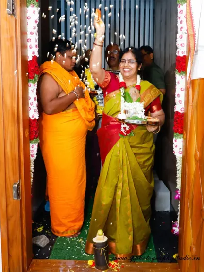 A candid shot of a woman's joyful expression as she participates in her housewarming ceremony, tossing flowers as she enters her new home.