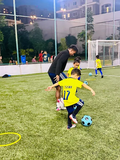 A coach interacting with a young player, showing the personal attention given to each child.