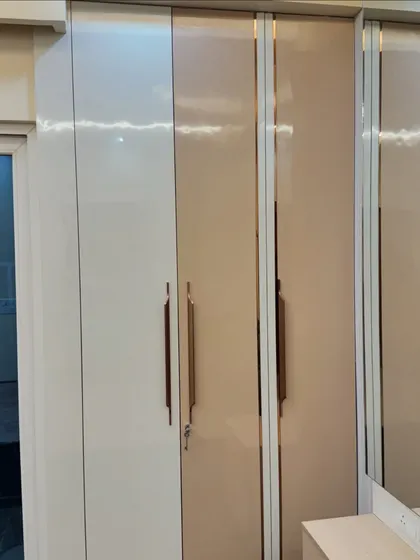 A close-up of the high-gloss laminate and the sleek profile handles that give this wardrobe its modern and luxurious appeal.