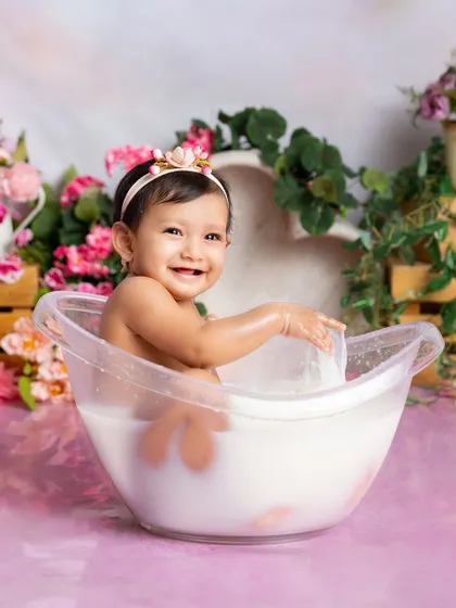 Making a splash! This action shot captures the fun and energy of a milk bath session, with water and a happy smile.