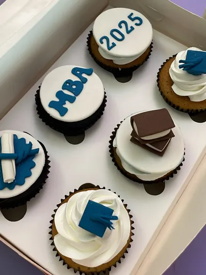 A set of cupcakes to celebrate a huge achievement: getting into an MBA program. The designs include graduation caps, books, and the year, all made from fondant.