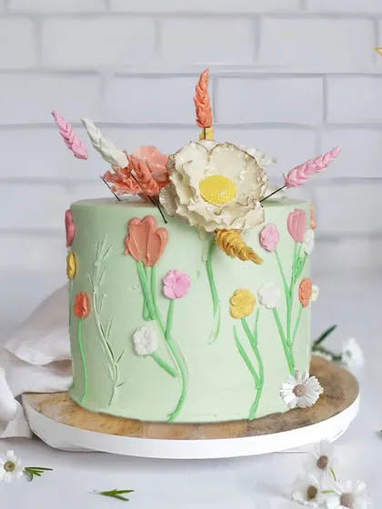 For Riya’s celebration in Sainik Farms, I crafted this dreamy flower-themed cake. The soft green frosting is adorned with delicate, hand-painted buttercream flowers, creating a true floral fantasy.
