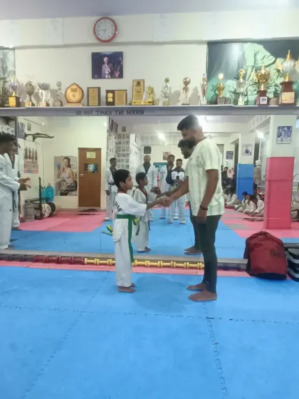 A student receives his green and yellow belt.